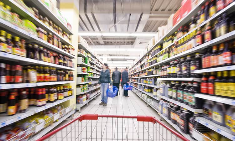 People shopping in a grocery store aisle.