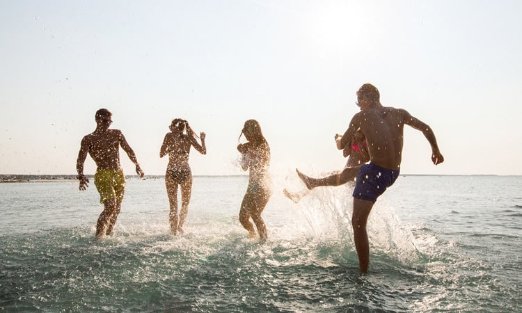 A group of people splashing around at the beach.